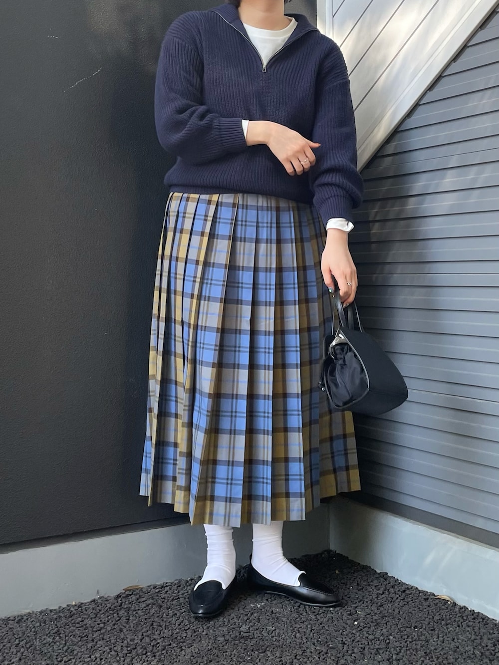 ブルー系のニット/セーター、ブルー系のスカート、ブラック系のショルダーバッグを着用したレディースの冬コーディネートの3枚目の写真