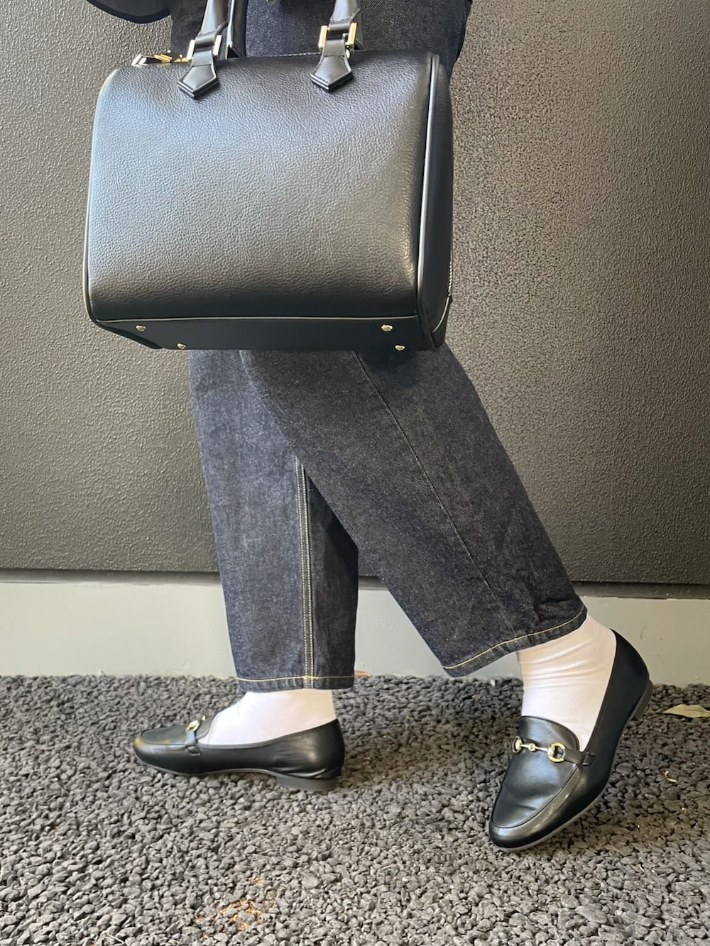 イエロー系のTシャツ/カットソー、ブラック系のシャツ/ブラウス、ブラック系のボストンバッグを着用したレディースの冬コーディネートの4枚目の写真