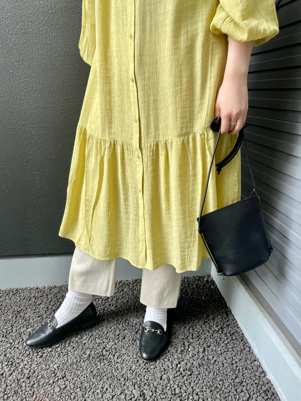 ブラック系のローファー、ブラック系のショルダーバッグ、イエロー系のワンピースを着用したレディースの冬コーディネートの5枚目の写真