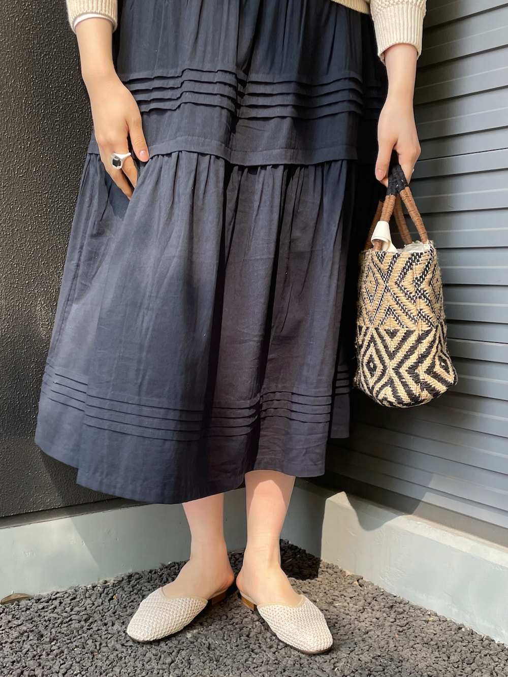 ホワイト系のニット/セーター、グレー系のスカートを着用したレディースの春コーディネートの3枚目の写真