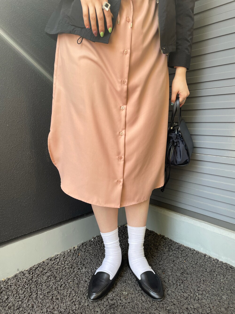 ブラック系のマウンテンパーカー、ピンク系のワンピース、ブラック系のスリッポンを着用したレディースの春コーディネートの3枚目の写真