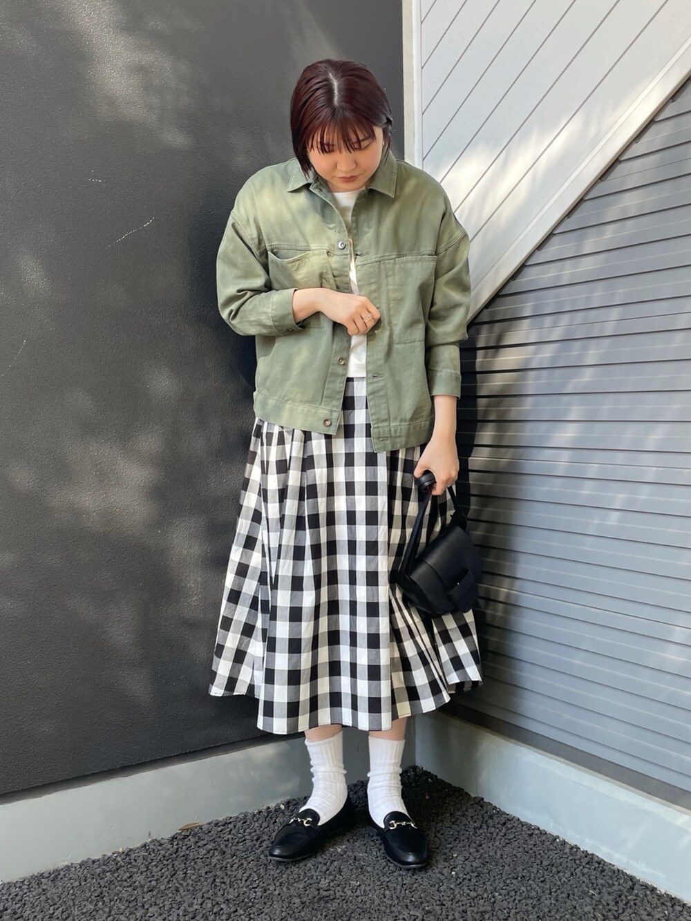 ブラック系のショルダーバッグ、ブラック系のローファー、その他のスカートを着用したレディースの冬コーディネートの2枚目の写真