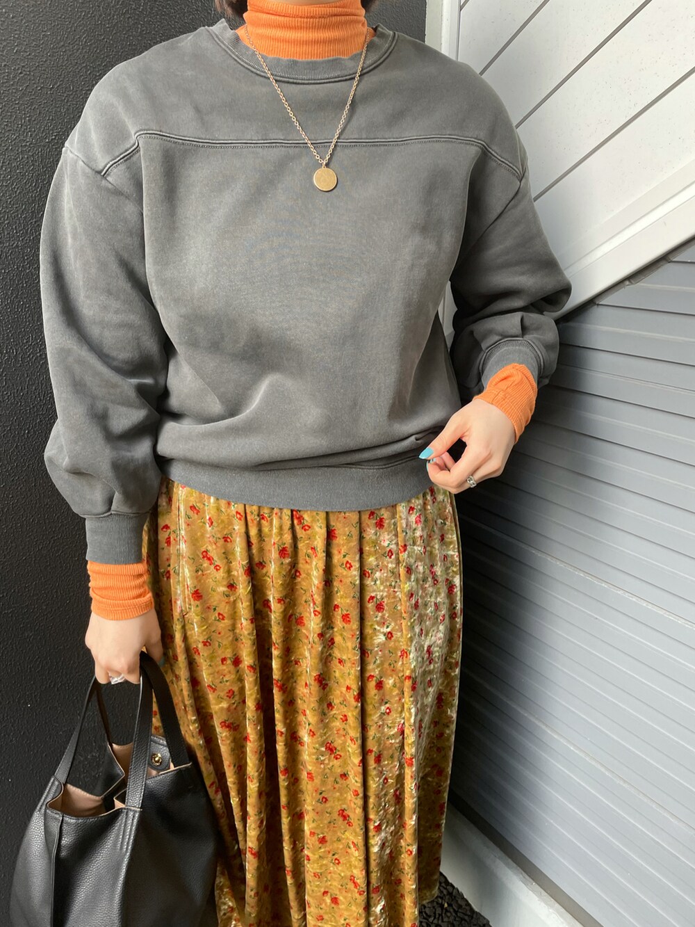 グレー系のスウェット、オレンジ系のTシャツ/カットソー、ブラック系のトートバッグを着用したレディースの冬コーディネートの2枚目の写真