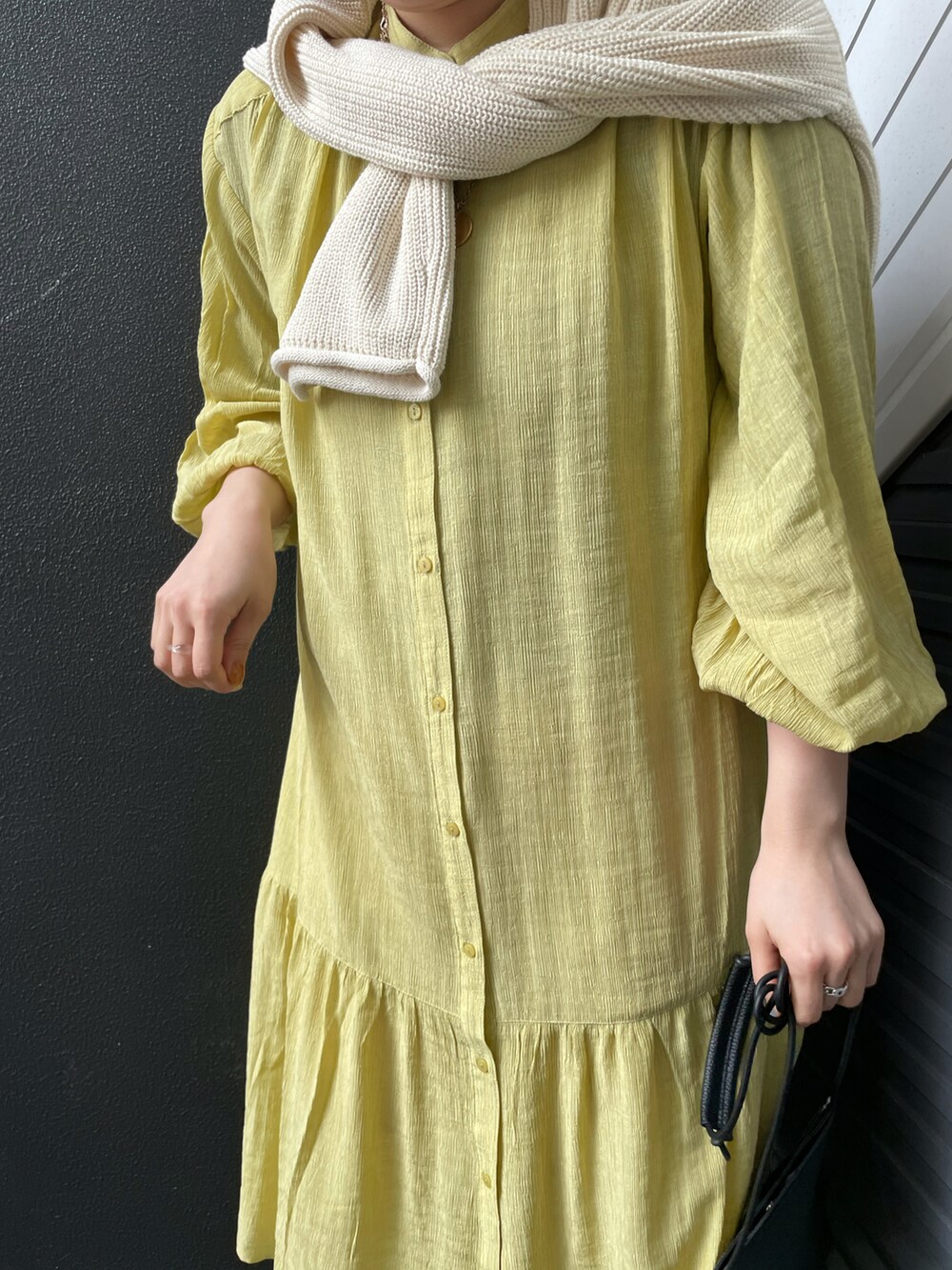 ブラック系のローファー、ブラック系のショルダーバッグ、イエロー系のワンピースを着用したレディースの冬コーディネートの4枚目の写真