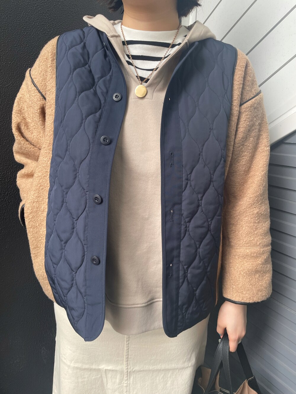 ブラウン系のブルゾン、ベージュ系のパーカー、ブラック系のTシャツ/カットソーを着用したレディースの冬コーディネートの3枚目の写真