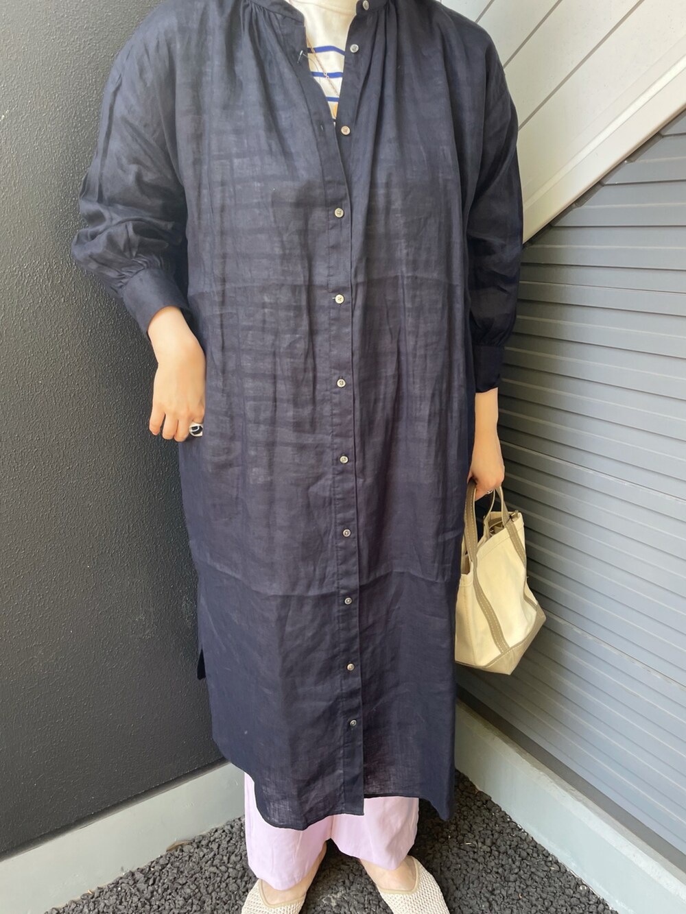 ブルー系のワンピース、ベージュ系のハンドバッグ、ブルー系のTシャツ/カットソーを着用したレディースの春コーディネートの3枚目の写真