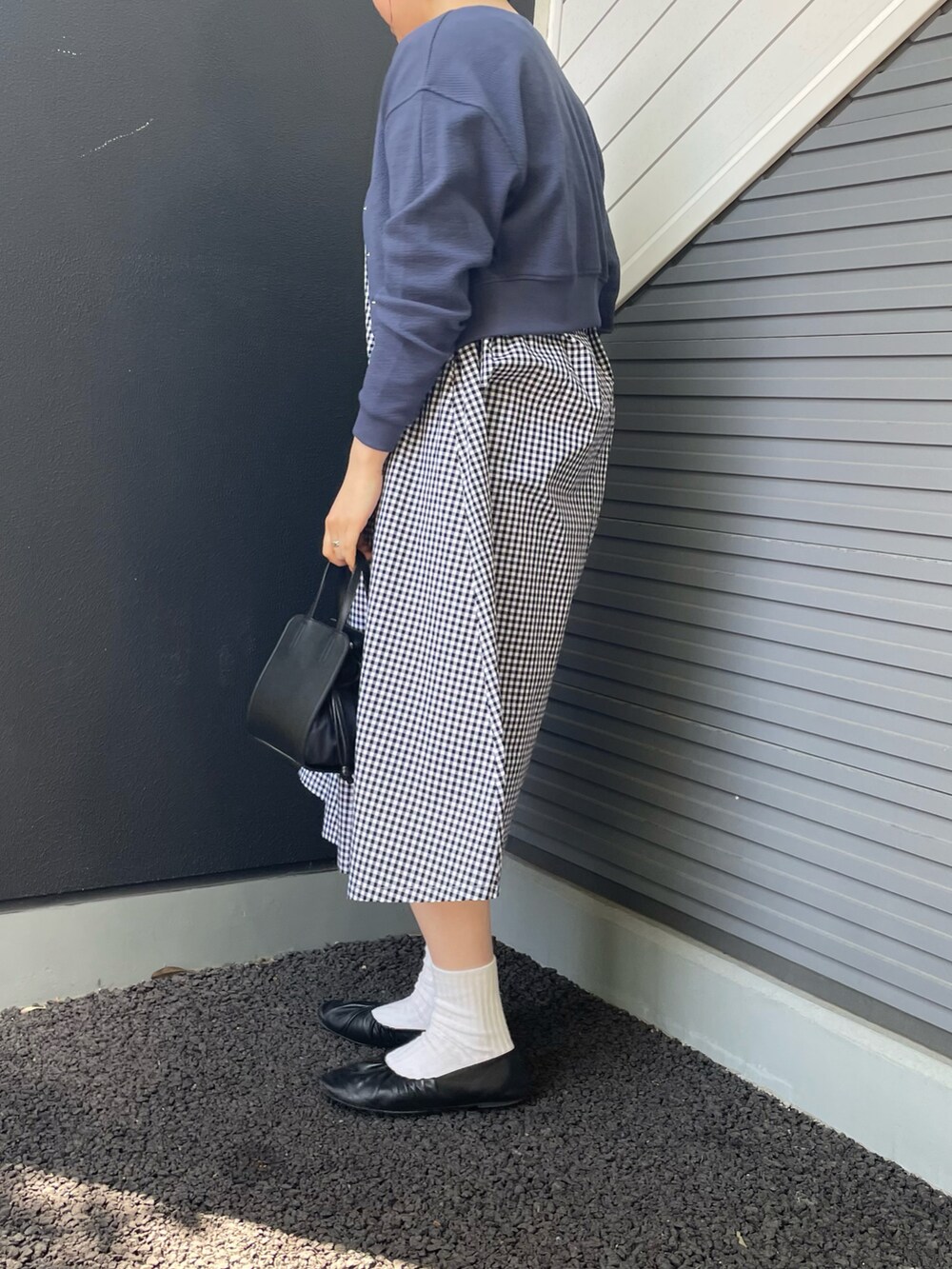 ブラック系のワンピース、ブルー系のカーディガン/ボレロ、ブラック系のショルダーバッグを着用したレディースの春コーディネートの2枚目の写真