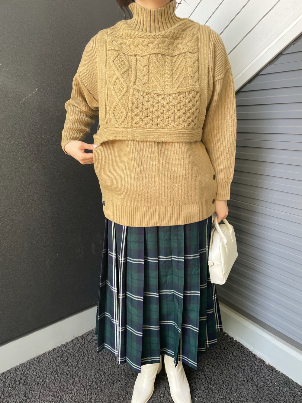 ベージュ系のベスト、ベージュ系のニット/セーター、ブルー系のスカートを着用したレディースの冬コーディネートの3枚目の写真