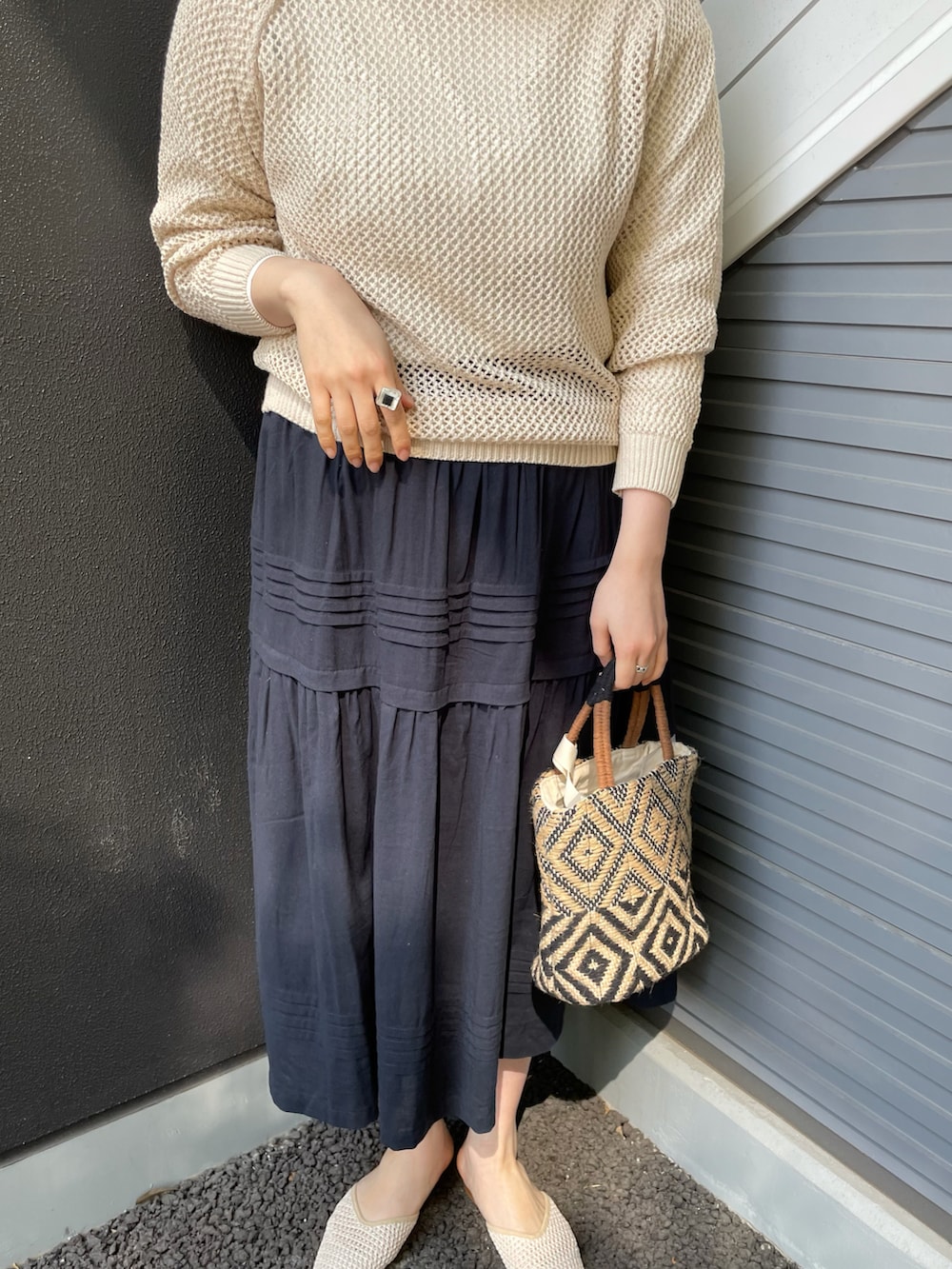 ホワイト系のニット/セーター、グレー系のスカートを着用したレディースの春コーディネートの2枚目の写真