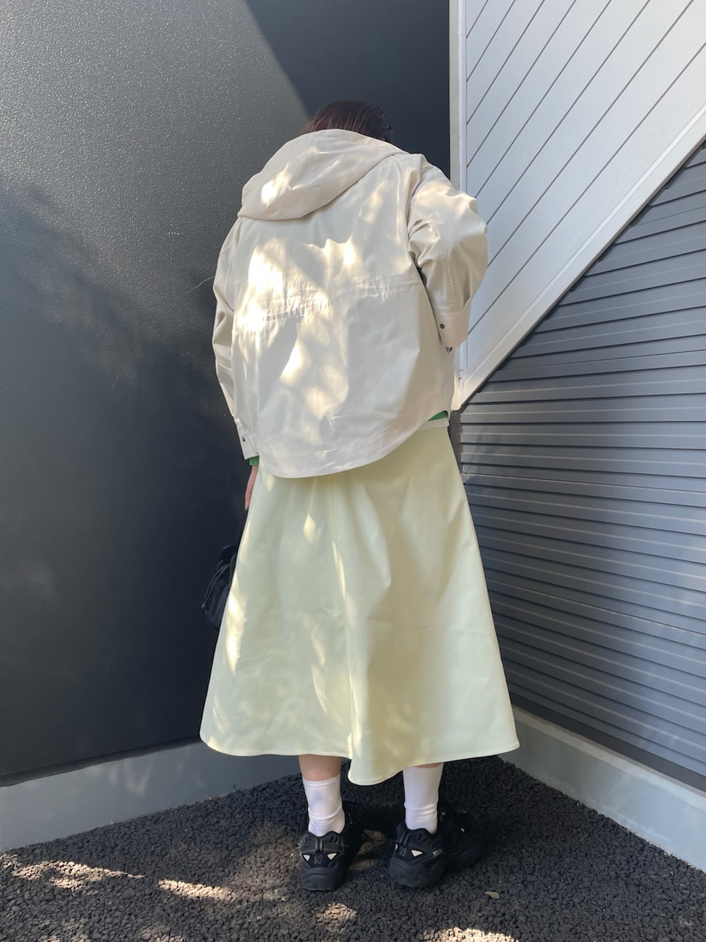 ホワイト系のマウンテンパーカー、グリーン系のスウェット、ブラック系のショルダーバッグを着用したレディースの冬コーディネートの2枚目の写真