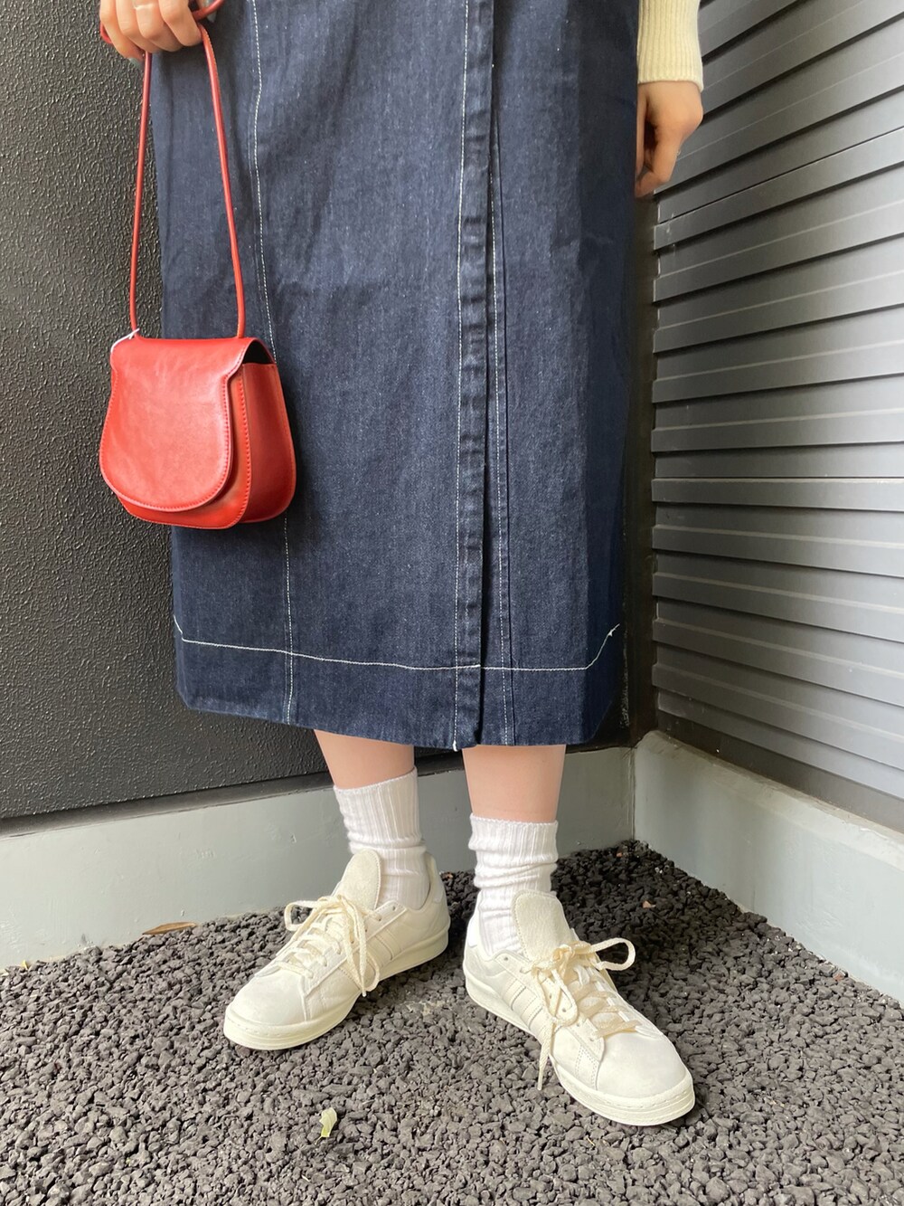 ブルー系のワンピース、ホワイト系のニット/セーター、レッド系のショルダーバッグを着用したレディースの冬コーディネートの4枚目の写真