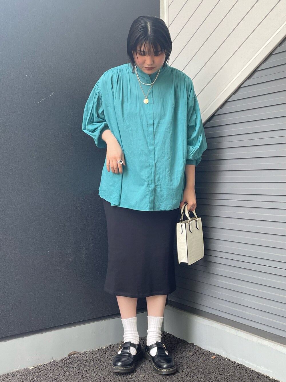 ブルー系のシャツ/ブラウス、ブラック系のスカート、ホワイト系のトートバッグを着用したレディースの春コーディネートの2枚目の写真