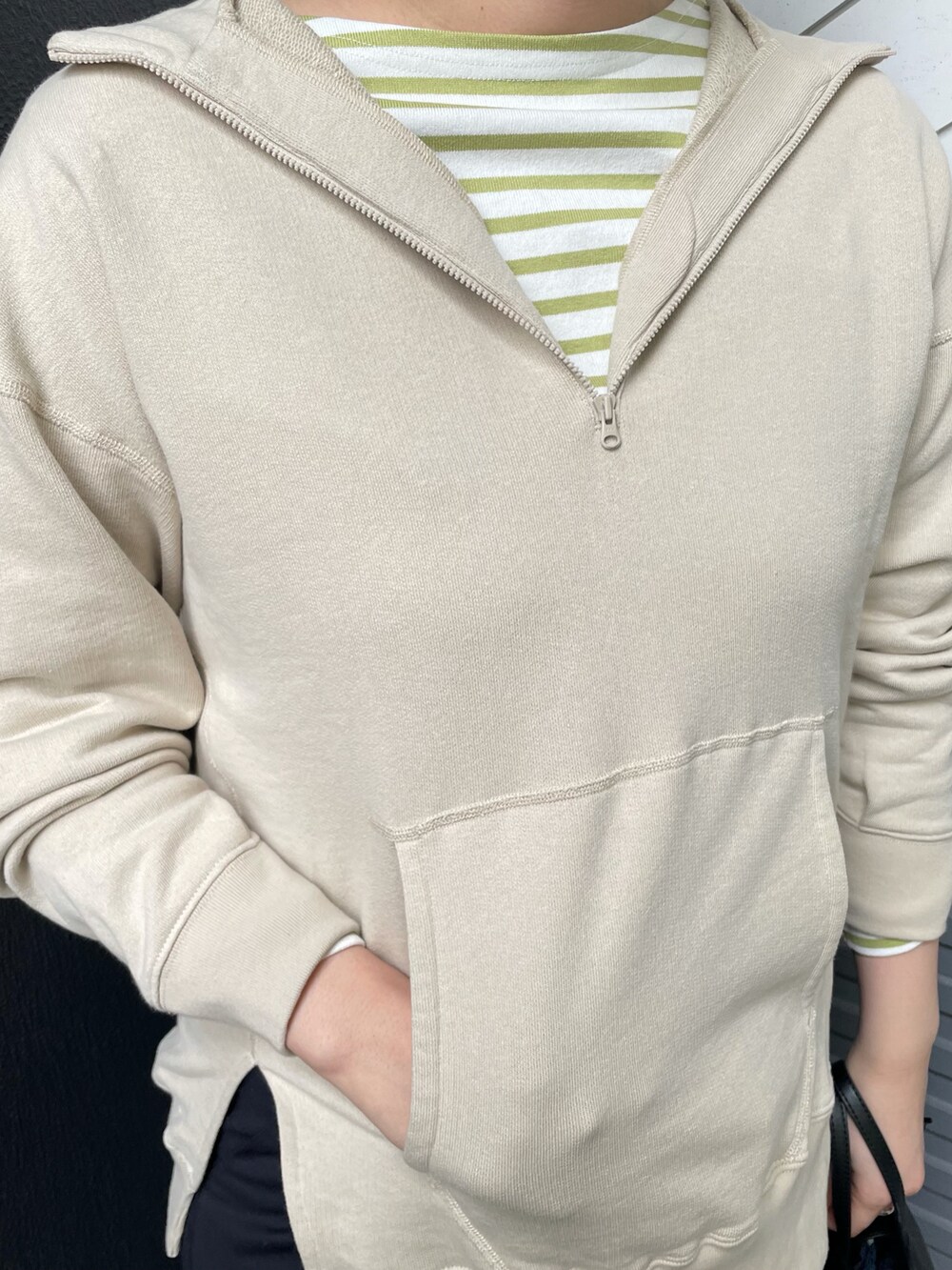 ベージュ系のパーカー、グリーン系のTシャツ/カットソー、ブラック系のショルダーバッグを着用したレディースの冬コーディネートの3枚目の写真