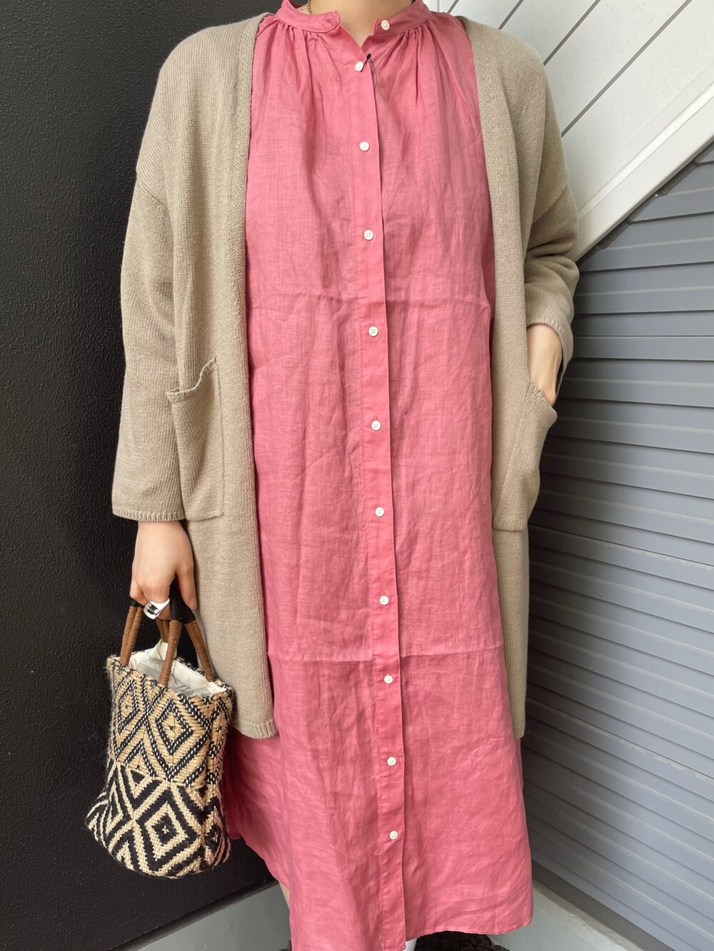 ピンク系のワンピース、ベージュ系のカーディガン/ボレロ、ブラック系のトートバッグを着用したレディースの春コーディネートの2枚目の写真