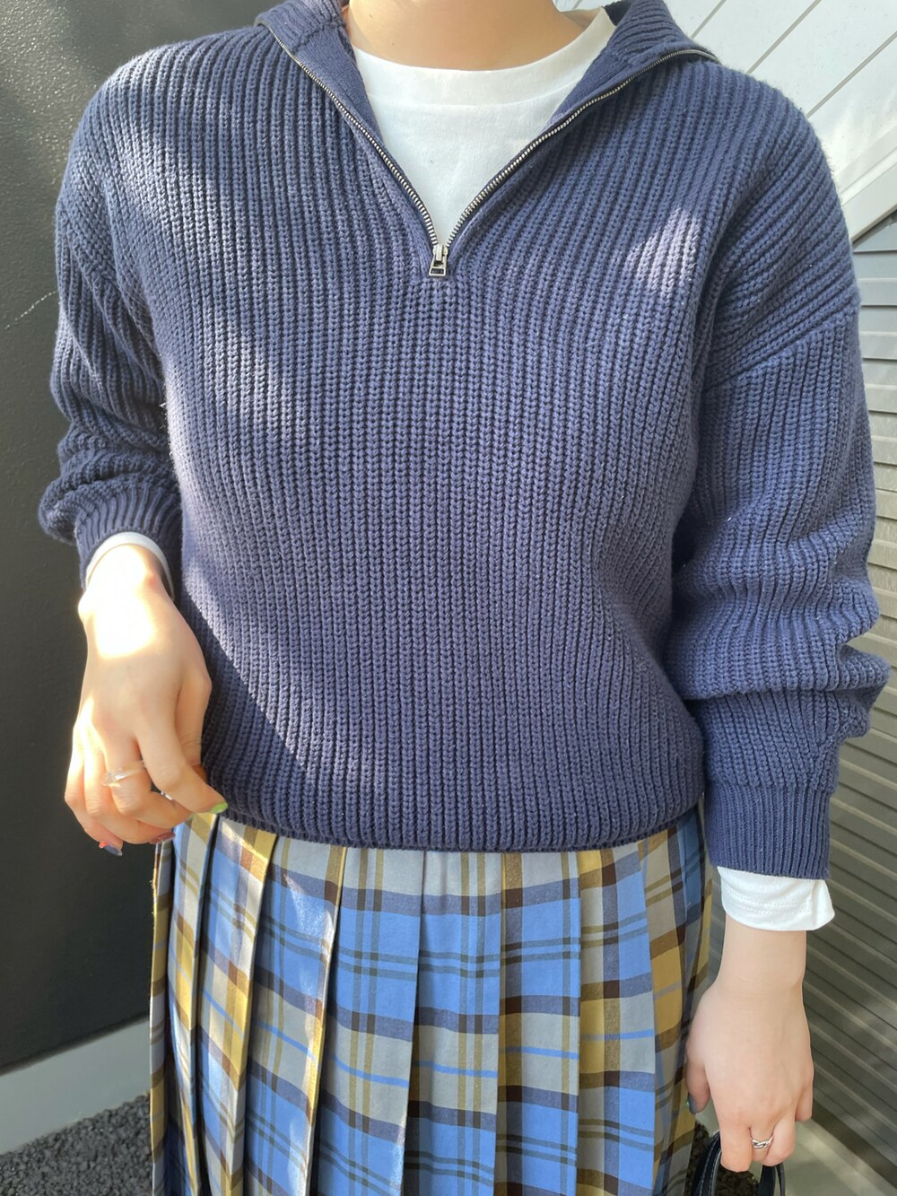 ブルー系のニット/セーター、ブルー系のスカート、ブラック系のショルダーバッグを着用したレディースの冬コーディネートの4枚目の写真