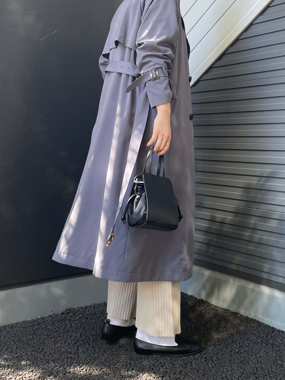 ブルー系のトレンチコート、ホワイト系のワンピース、ブラック系のショルダーバッグを着用したレディースの冬コーディネートの2枚目の写真