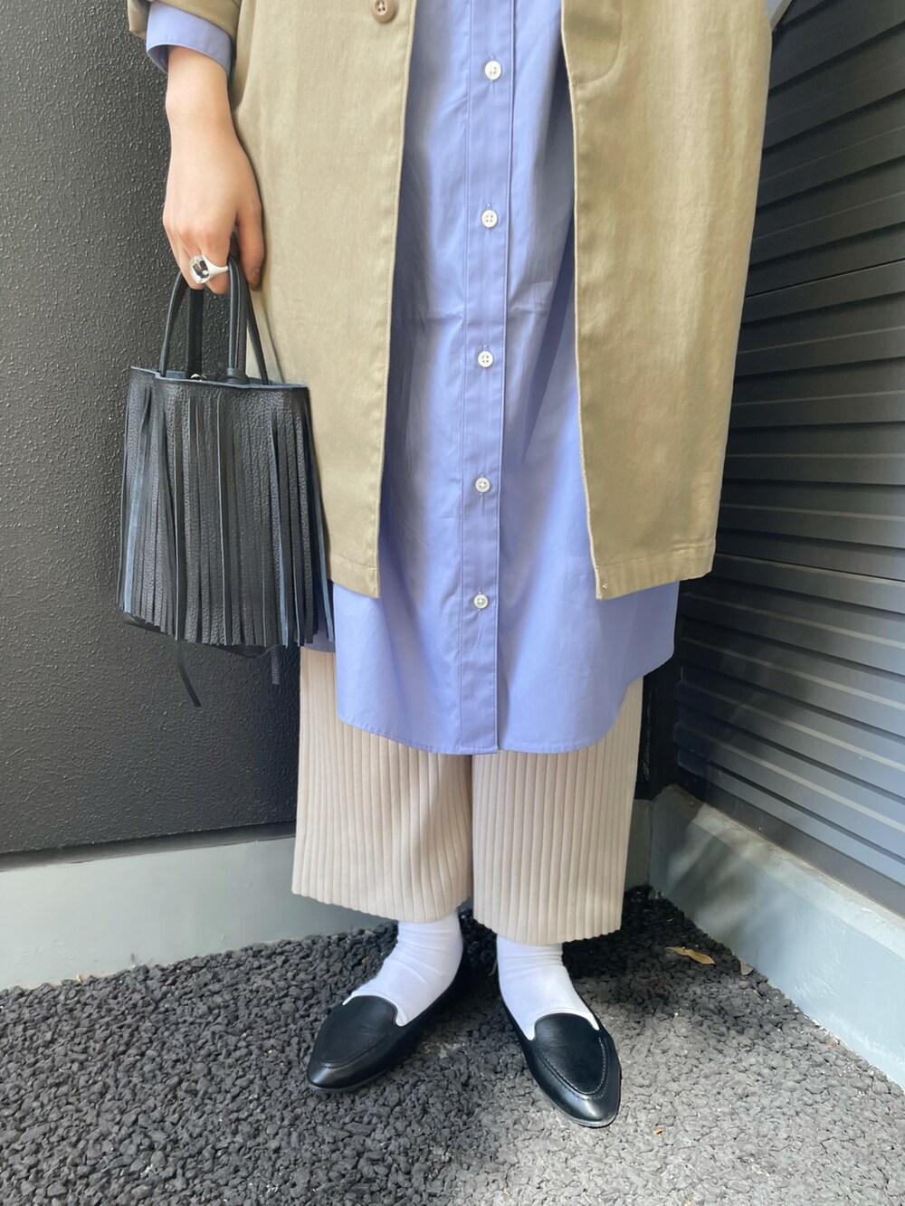 ベージュ系のステンカラーコート、ブルー系のワンピース、ブラック系のハンドバッグを着用したレディースの冬コーディネートの3枚目の写真