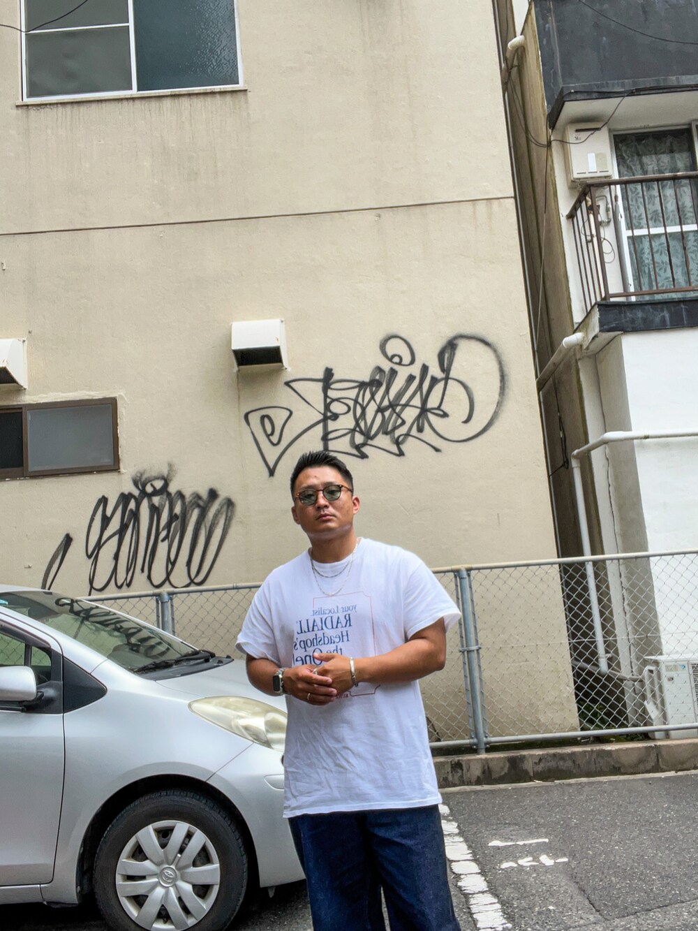 ホワイト系のTシャツ/カットソー、ブルー系のデニムパンツ、ブラック系のローファーを着用したメンズの夏コーディネートの2枚目の写真