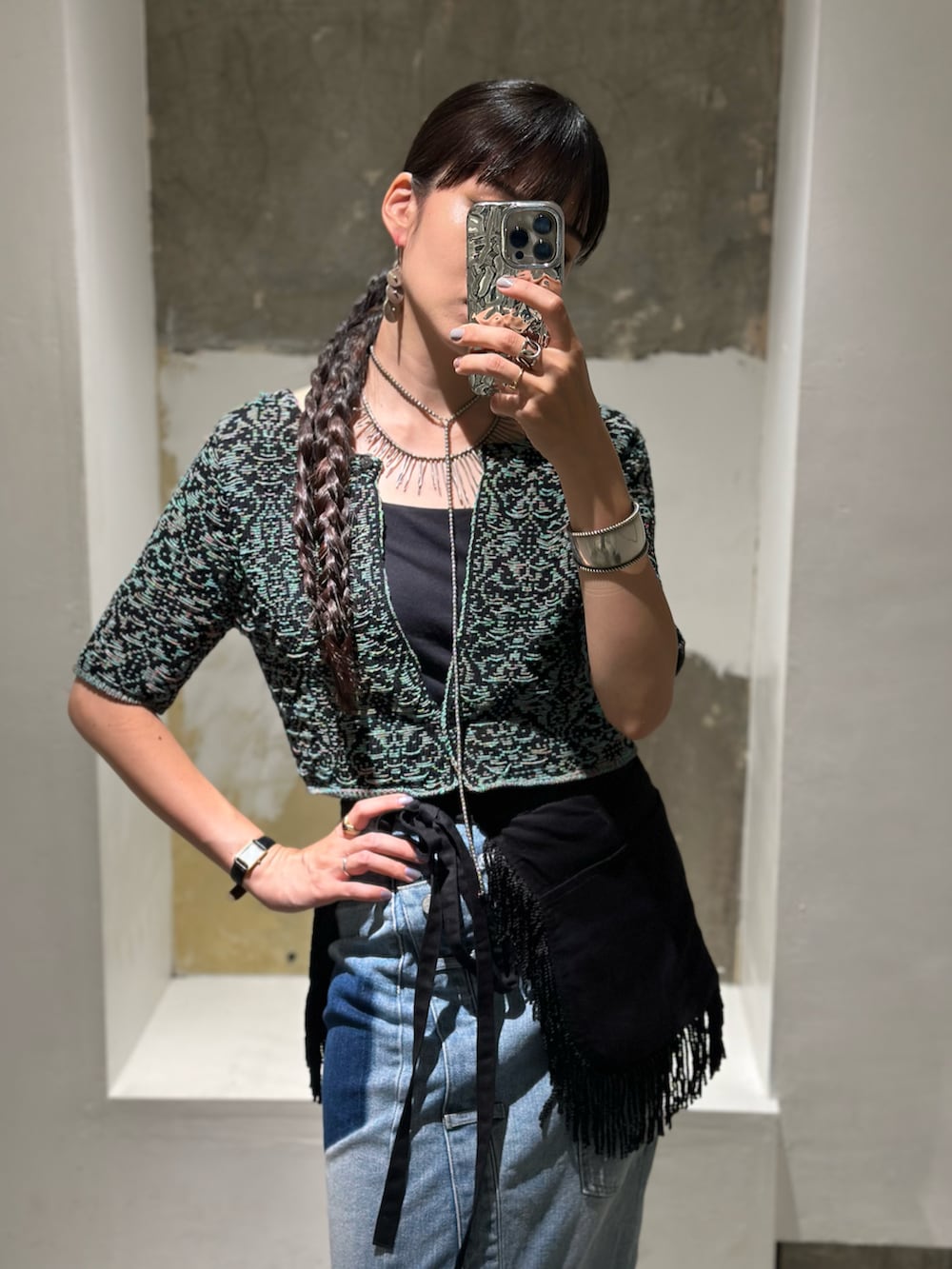 ブルー系のデニムスカート、ブラック系のブーツ、ブラック系のスカートを着用したレディースの秋コーディネートの3枚目の写真