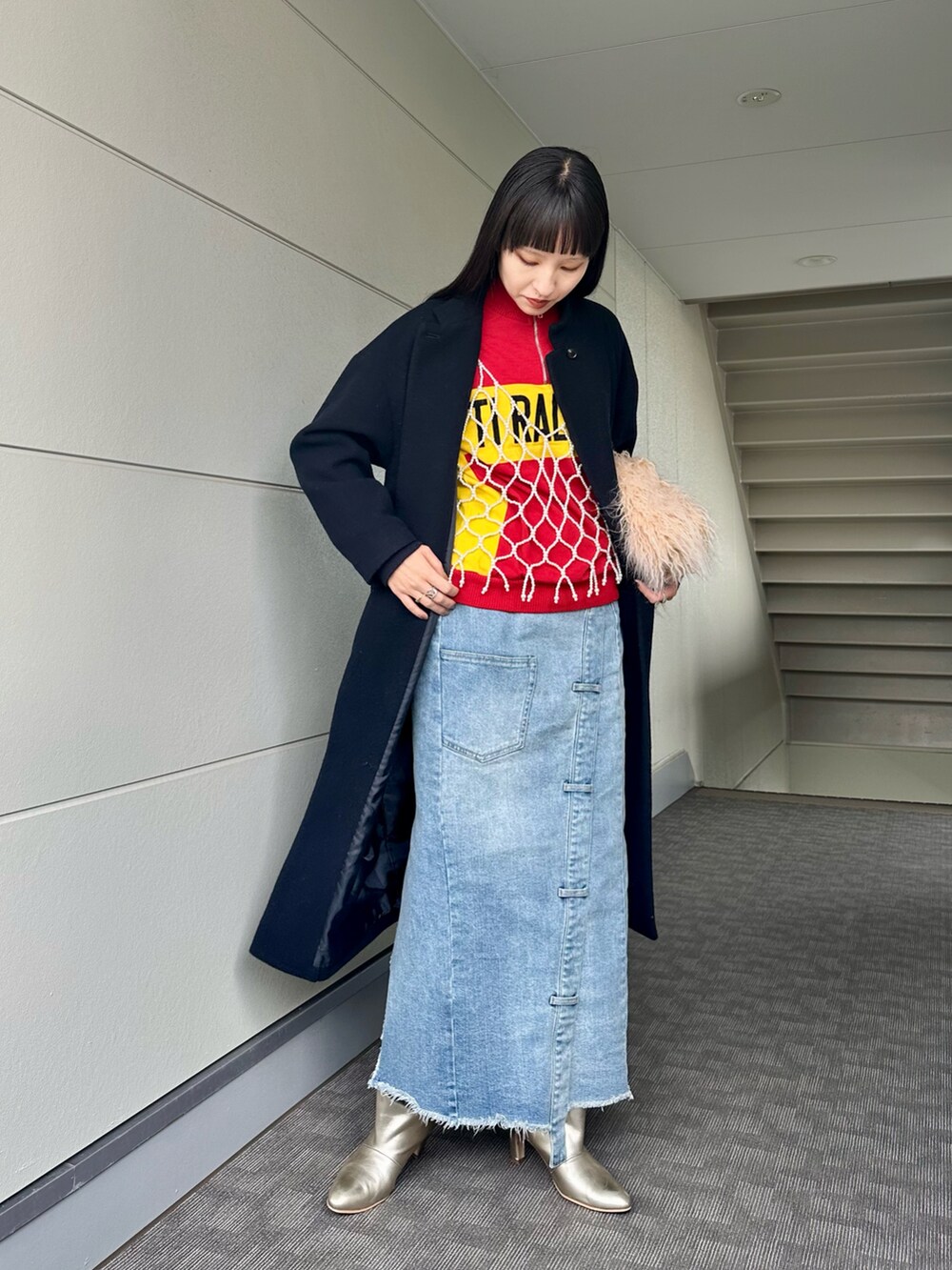 ゴールド系のブーツ、ブルー系のデニムスカート、その他のキャミソールを着用したレディースの冬コーディネートの4枚目の写真