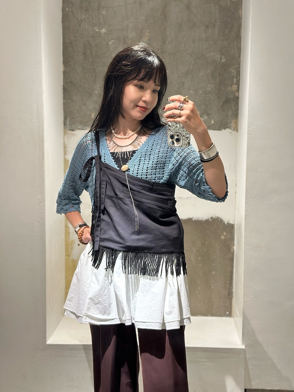 ブラウン系のその他パンツ、ブラック系のスカート、ブルー系のカーディガン/ボレロを着用したレディースの秋コーディネートの2枚目の写真