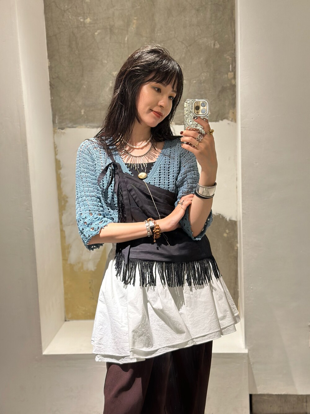 ブラウン系のその他パンツ、ブラック系のスカート、ブルー系のカーディガン/ボレロを着用したレディースの秋コーディネートの3枚目の写真