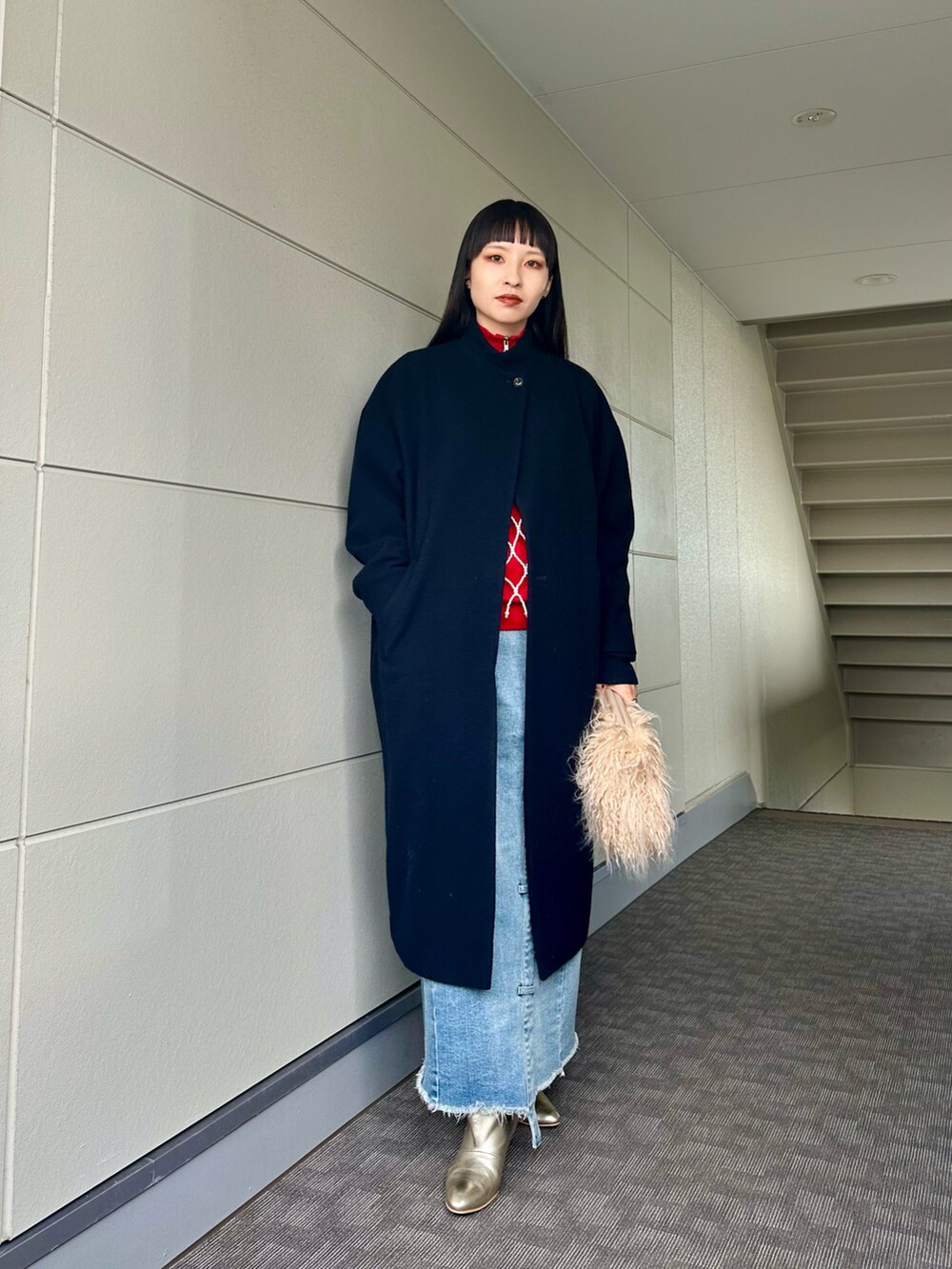 ゴールド系のブーツ、ブルー系のデニムスカート、その他のキャミソールを着用したレディースの冬コーディネートの3枚目の写真