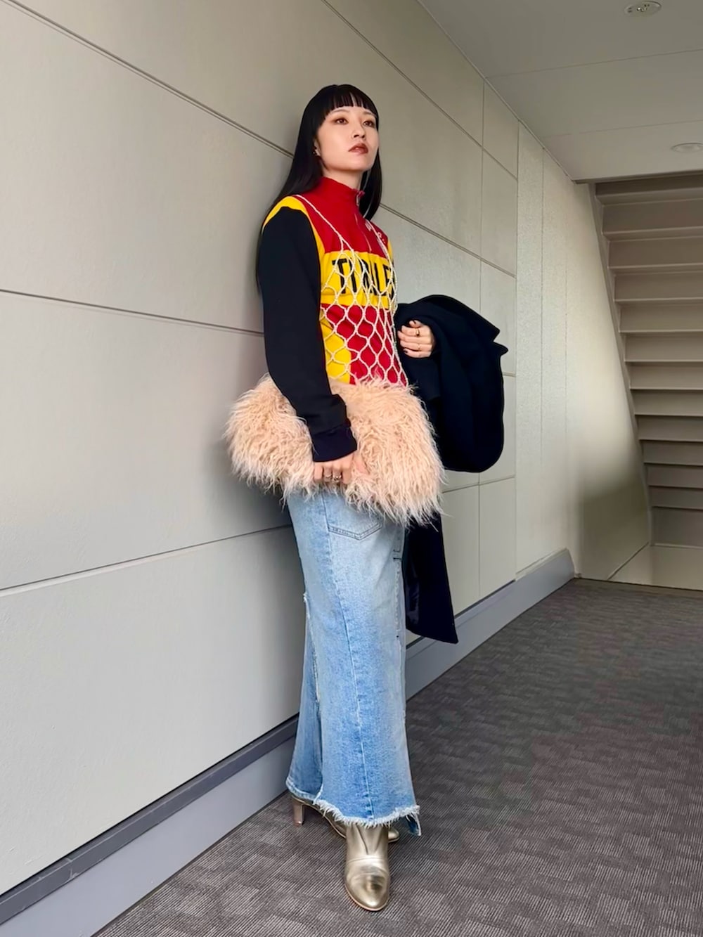 ゴールド系のブーツ、ブルー系のデニムスカート、その他のキャミソールを着用したレディースの冬コーディネートの5枚目の写真