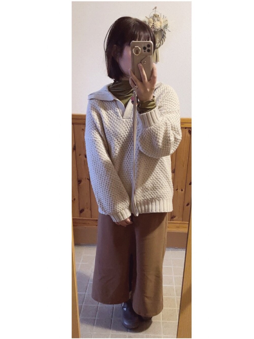 ベージュ系のニット/セーター、ブラウン系のスカート、イエロー系のTシャツ/カットソーを着用したレディースの冬コーディネートの2枚目の写真