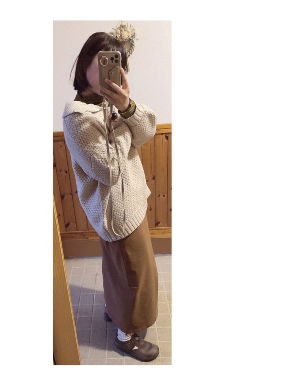 ベージュ系のニット/セーター、ブラウン系のスカート、イエロー系のTシャツ/カットソーを着用したレディースの冬コーディネートの3枚目の写真