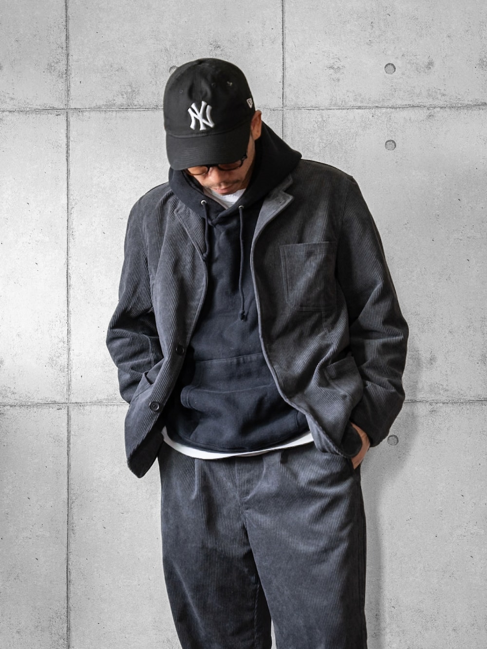 グレー系のセットアップ、ブラック系のローファー、ブラック系のキャップを着用したメンズの秋コーディネートの2枚目の写真