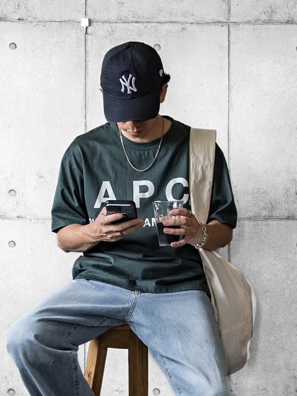 ブルー系のデニムパンツ、ホワイト系のショルダーバッグ、グリーン系のTシャツ/カットソーを着用したメンズの夏コーディネートの2枚目の写真