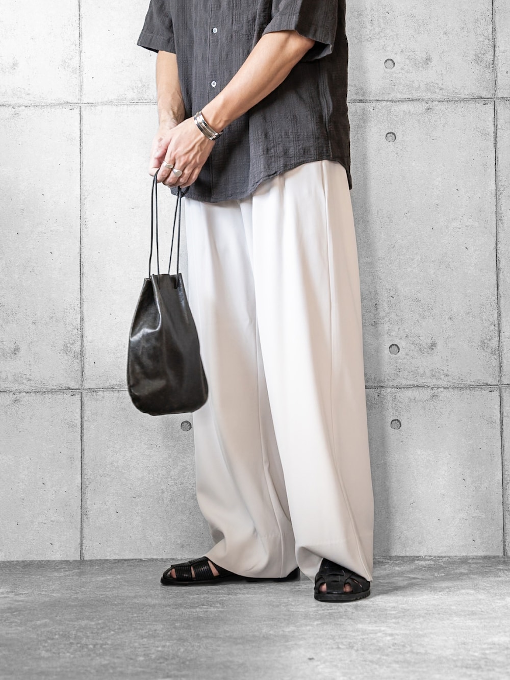 グレー系のシャツ/ブラウス、ホワイト系のスラックス、ブラック系のショルダーバッグを着用したメンズの夏コーディネートの3枚目の写真