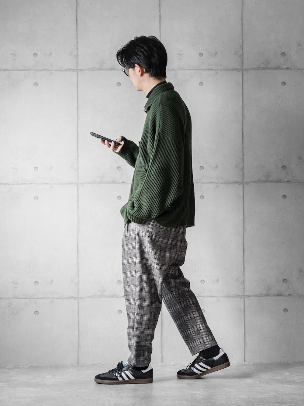 グリーン系のニット/セーター、ブラック系のその他パンツ、ブラック系のスニーカーを着用したメンズの冬コーディネートの2枚目の写真