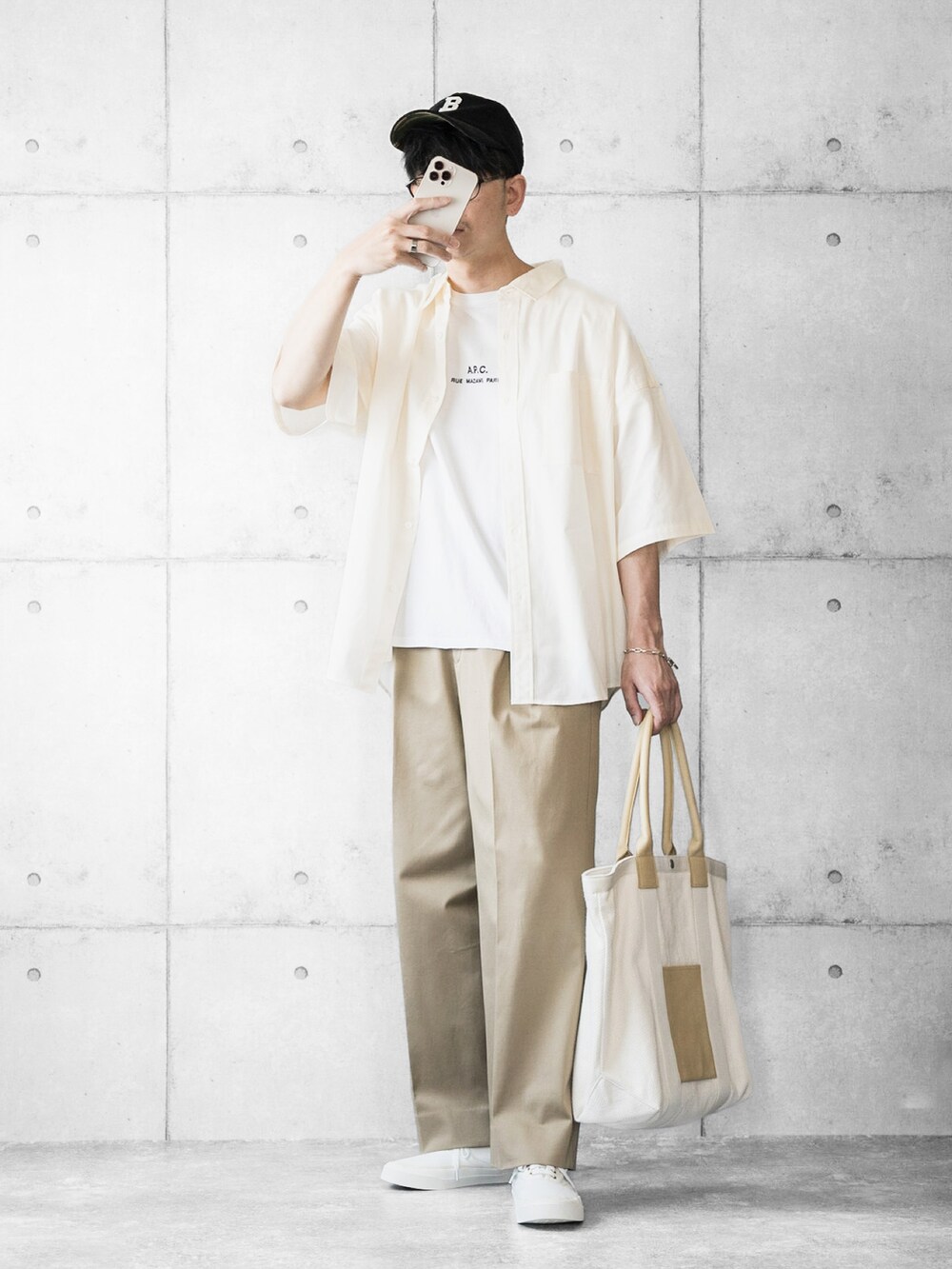 ホワイト系のシャツ/ブラウス、ベージュ系のチノパンツ、ベージュ系のトートバッグを着用したメンズの春コーディネートの2枚目の写真