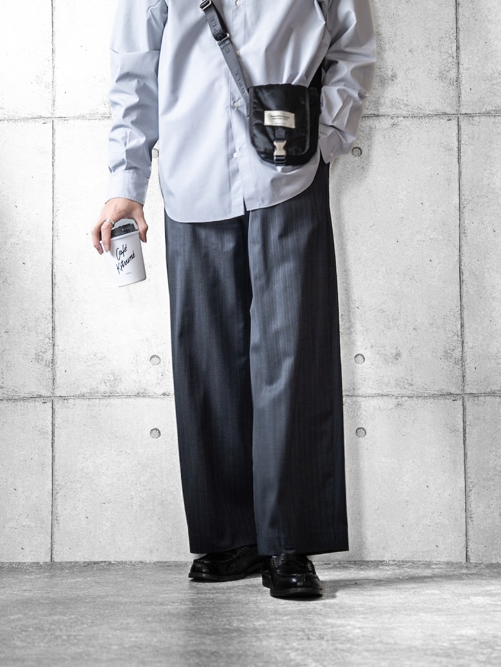 ブルー系のシャツ/ブラウス、ブラック系のローファー、グレー系のスラックスを着用したメンズの冬コーディネートの3枚目の写真