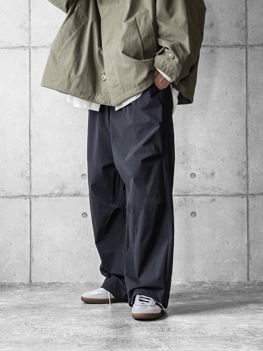 グリーン系のブルゾン、ホワイト系のシャツ/ブラウス、ブラック系のその他パンツを着用したメンズの秋コーディネートの3枚目の写真