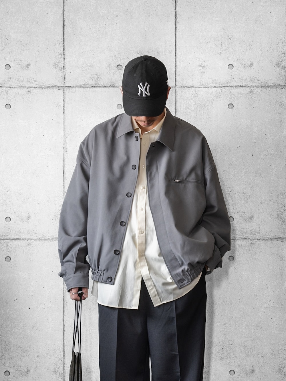 グレー系のブルゾン、イエロー系のシャツ/ブラウス、ブラック系のスラックスを着用したメンズの春コーディネートの2枚目の写真