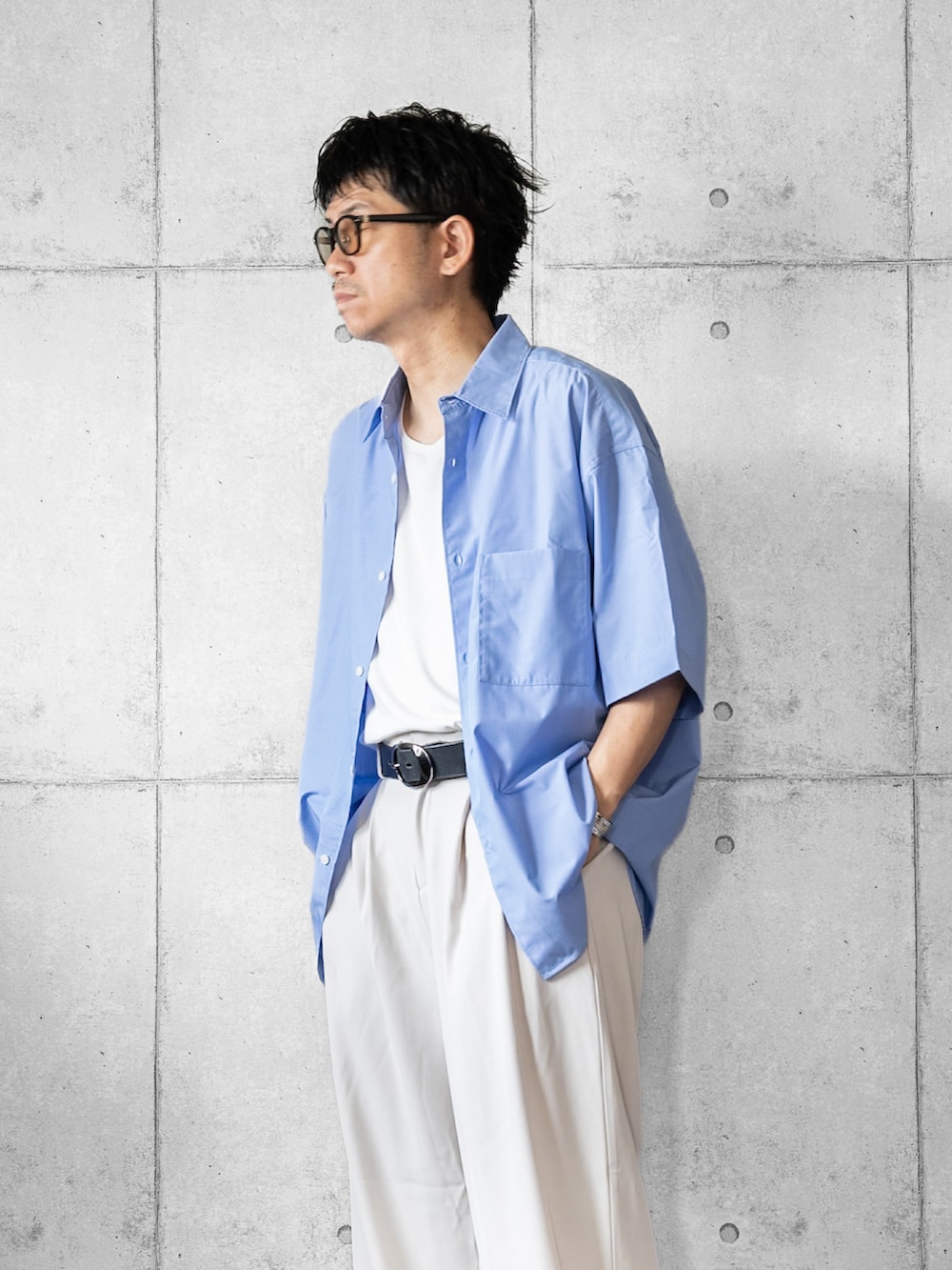 ブルー系のシャツ/ブラウス、ホワイト系のスラックス、ブラック系のローファーを着用したメンズの夏コーディネートの2枚目の写真