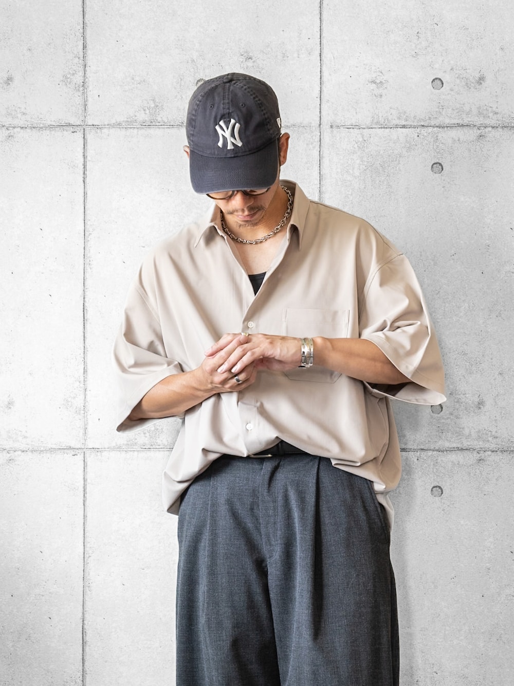 ベージュ系のシャツ/ブラウス、グレー系のスラックス、ブラック系のサンダルを着用したメンズの夏コーディネートの2枚目の写真
