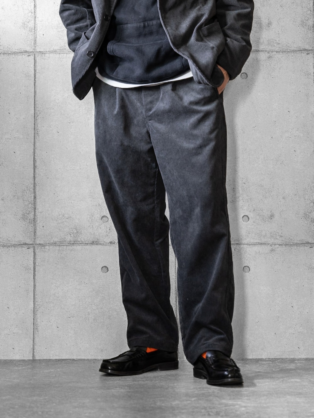 グレー系のセットアップ、ブラック系のローファー、ブラック系のキャップを着用したメンズの秋コーディネートの3枚目の写真