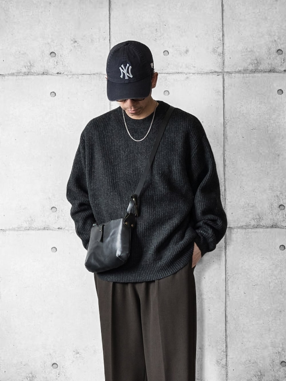 グレー系のニット/セーター、ブラウン系のスラックス、ブラウン系のローファーを着用したメンズの冬コーディネートの2枚目の写真