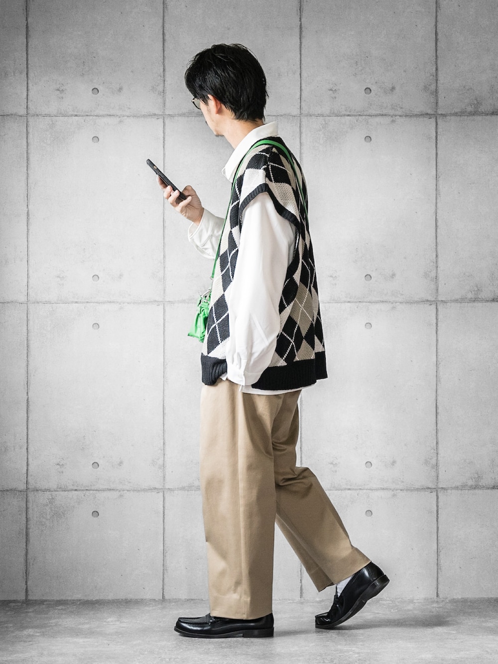 「ニットベスト、アーガイル柄、白シャツ、チノパン、ワイドパンツ、ローファー、ショルダーバッグ、グリーン、秋コーデ、休日スタイル、PR」|「WONDER WONDERの羽根つきベスト / アーガイル柄オーバーサイズニット(ベスト、ブラック系)」を使った、しゅんたろーさん(メンズ・177cm)の秋コーディネートの2枚目の写真