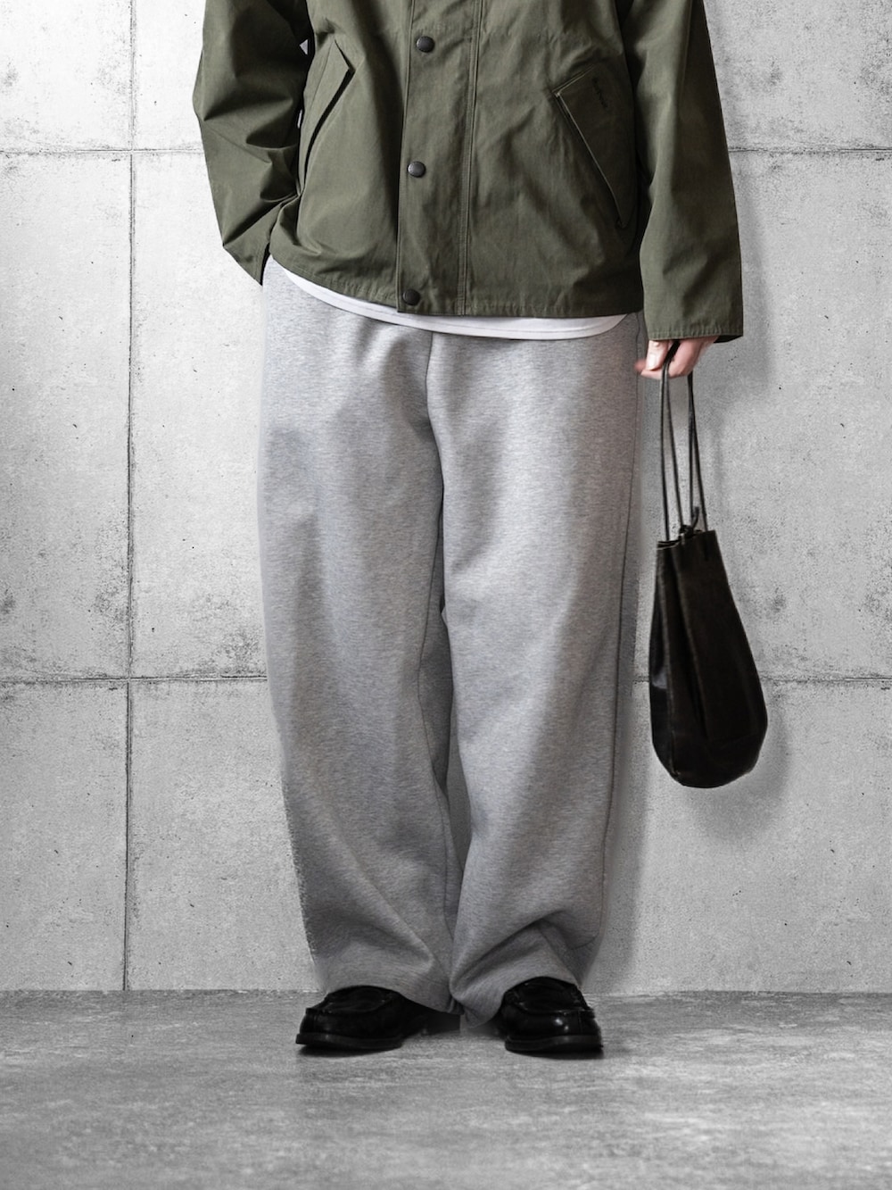 グリーン系のブルゾン、ブラック系のショルダーバッグ、ブラック系のローファーを着用したメンズの冬コーディネートの3枚目の写真