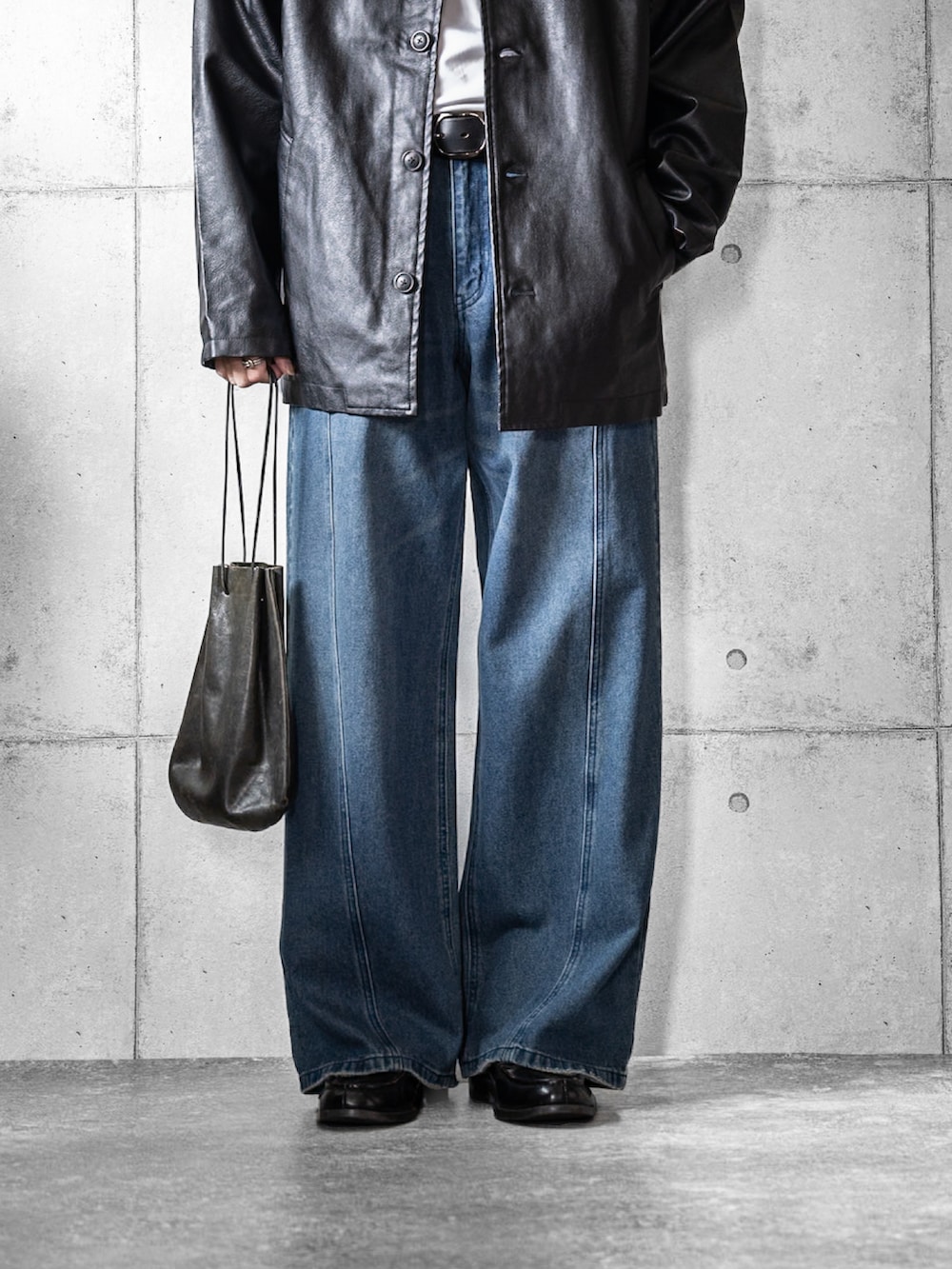 ブラック系のブルゾン、ブルー系のデニムパンツ、ブラック系のショルダーバッグを着用したメンズの春コーディネートの3枚目の写真