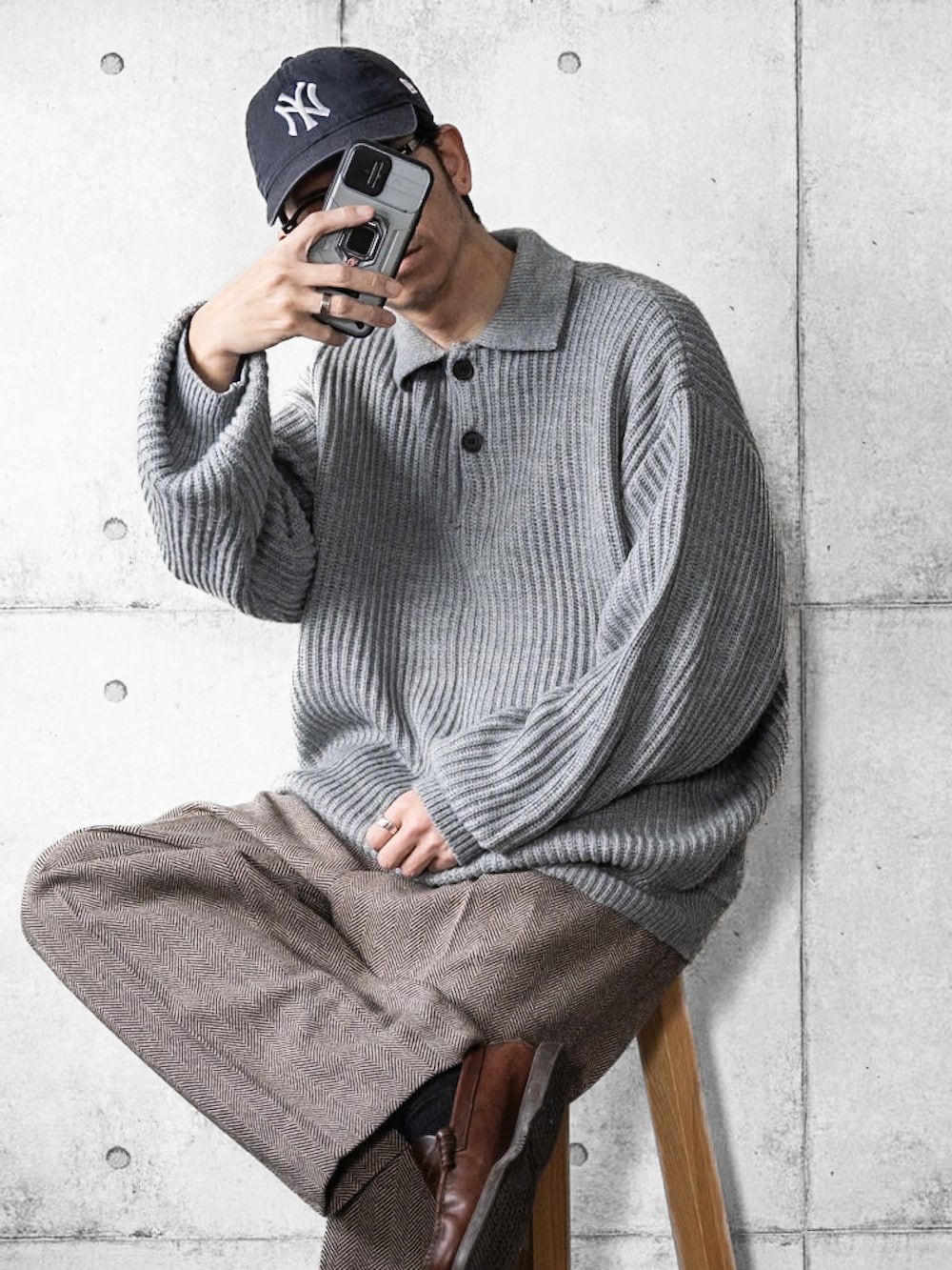 グレー系のニット/セーター、ブラウン系のスラックス、ブラウン系のローファーを着用したメンズの冬コーディネートの2枚目の写真
