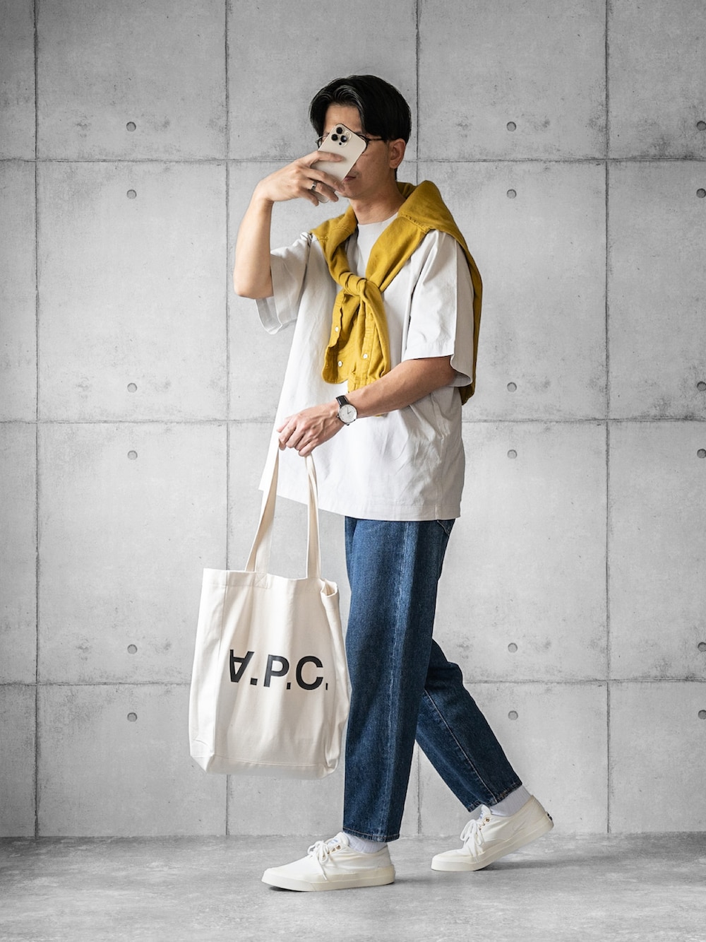 グレー系のTシャツ/カットソー、ブルー系のデニムパンツ、ホワイト系のスニーカーを着用したメンズの春コーディネートの2枚目の写真