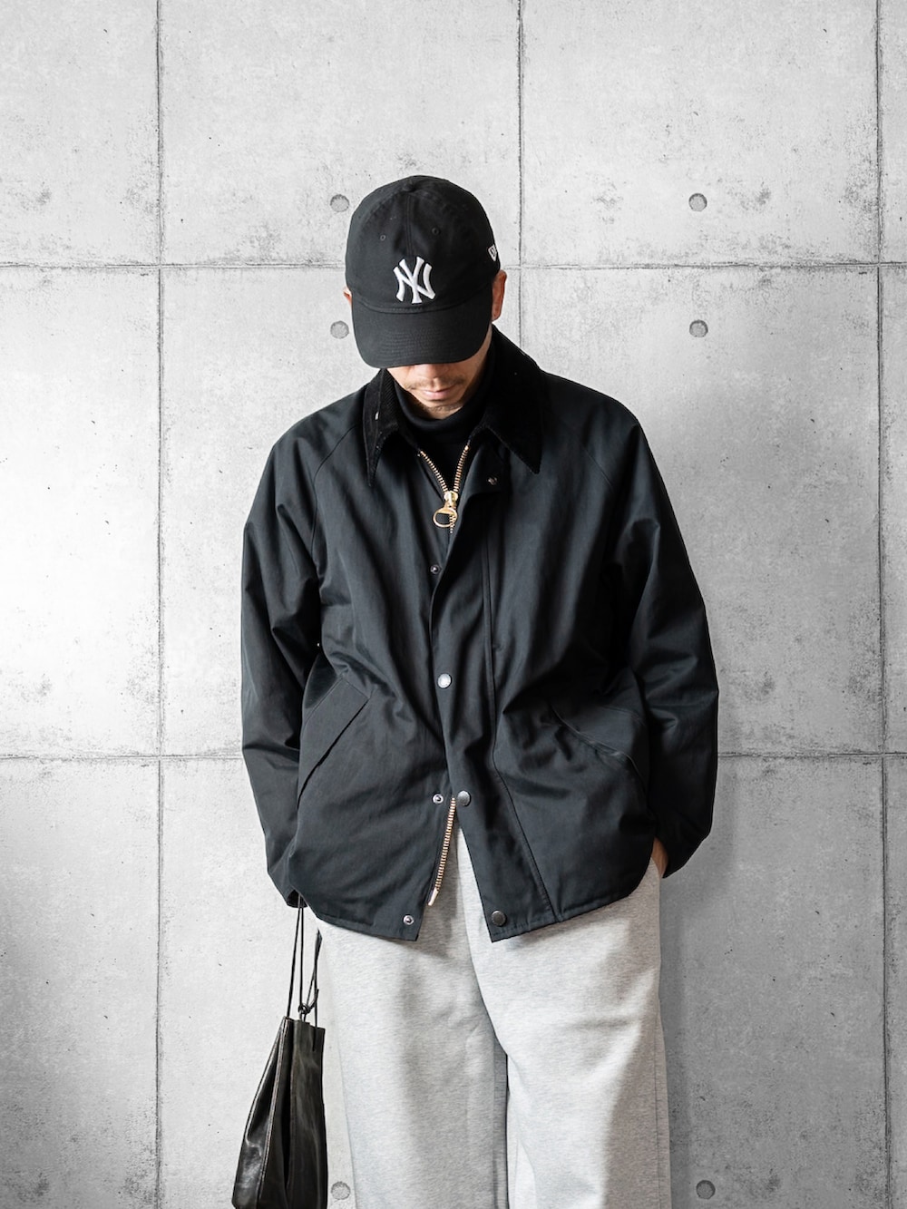 ブラック系のショルダーバッグ、ブラック系のローファー、ブラック系のブルゾンを着用したメンズの冬コーディネートの2枚目の写真