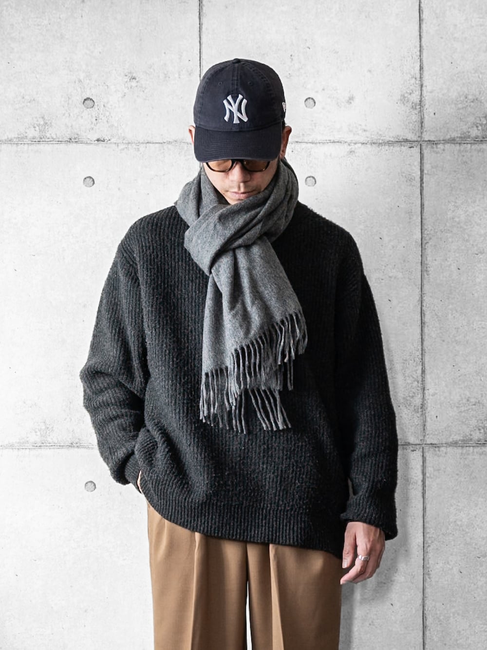 グレー系のニット/セーター、ベージュ系のスラックス、ブラック系のローファーを着用したメンズの冬コーディネートの2枚目の写真