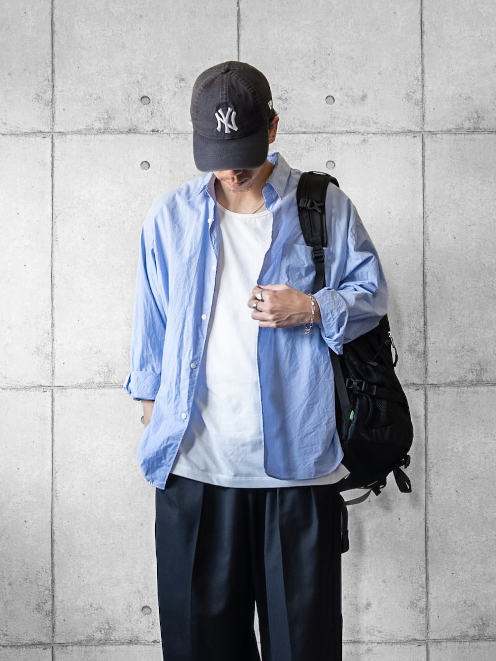 ブラック系のスラックス、ブラック系のスニーカー、ブルー系のシャツ/ブラウスを着用したメンズの秋コーディネートの2枚目の写真